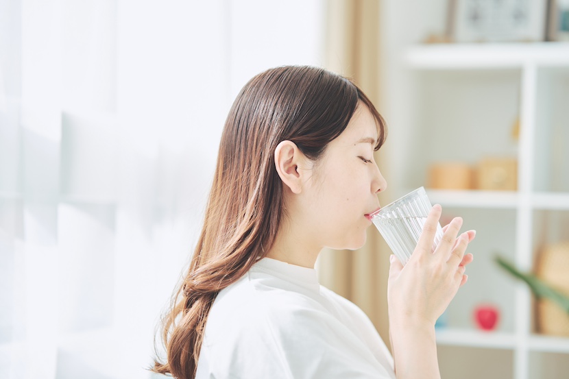部屋で水を飲む女性の画像